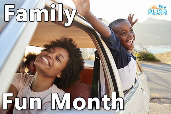 Mom and kids - young 5 year child jubilantly stretching through open window while mother smiles and second child sits in back of car