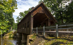Emerts Cove Covered Bridge surrounded by trees in Sevierville, Tennessee, with wooden architecture and creek – used by Bliss Products and Services for regional visual representation.