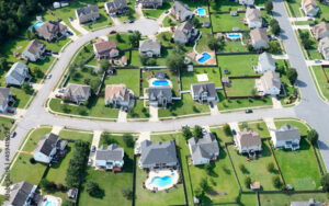 Aerial view of suburban neighborhoods in Chesapeake, Virginia, with residential homes, pools, and green lawns. Bliss Products and Services supports community projects in neighborhoods like these.