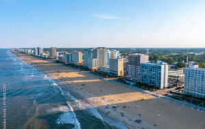 Aerial view of Virginia Beach oceanfront at sunset, showing hotels and shoreline featured by Bliss Products and Services.