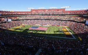 Full stadium view at FedExField during a football game, with American flag presentation, used by Bliss Products and Services.