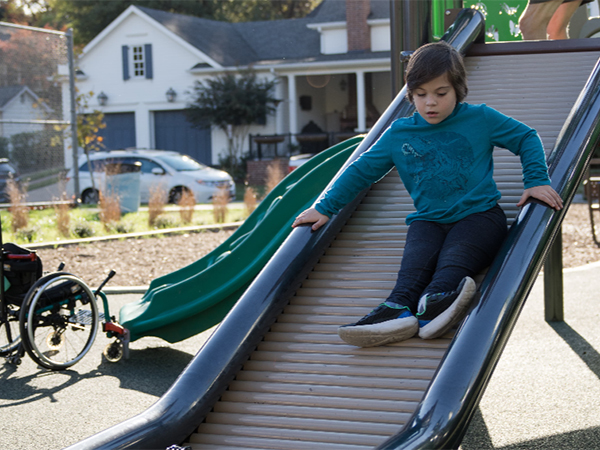 Child and adult interacting on an accessible slide at Riverview Park’s inclusive playground in Chattanooga, Tennessee, installed by Bliss Products and Services.