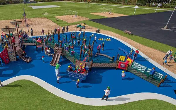 Overhead view of an inclusive playground with blue poured-in-place surfacing, available from Bliss Products and Services.