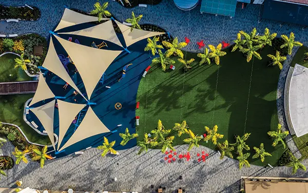 Overhead view of a neighborhood playground with swing bays, rope pyramid, and central shade, available from Bliss Products and Services.