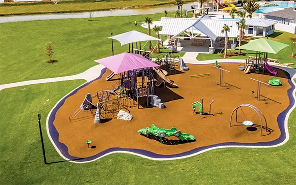 Overhead view of a park playground with multiple shade canopies and open lawn in Clay County, Alabama, available from Bliss Products and Services.
