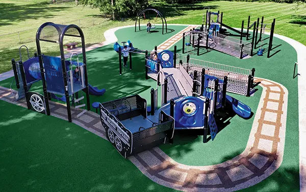 Aerial view of a train-themed inclusive playground with ramps and looped routes in Fayette, Fayette County, Alabama, available from Bliss Products and Services.