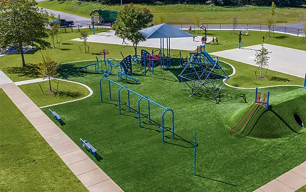 Overhead view of a playground with shade structures and sculpted turf mounds, available from Bliss Products and Services.