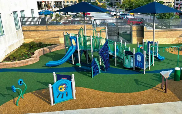 Compact playground with shade umbrellas and poured-in-place surfacing in Eutaw, Greene county, Alabama, available from Bliss Products and Services.