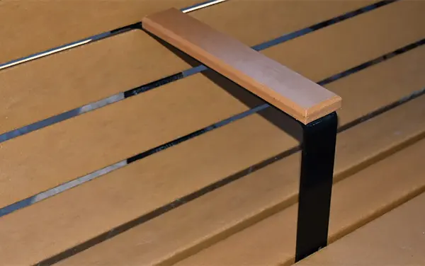 Installed center armrest on recycled-plastic park bench, used as a product image for the Bartram Park card.