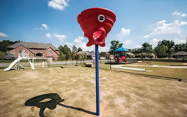 Red funnel ball playground game on a blue post at a park in Pine Grove, Alabama, available from Bliss Products and Services.