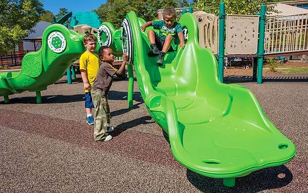 Kids in Ohatchee, Calhoun County, Alabama enjoying a sculpted inclusive slide with a tactile play wheel, available from Bliss Products and Services.
