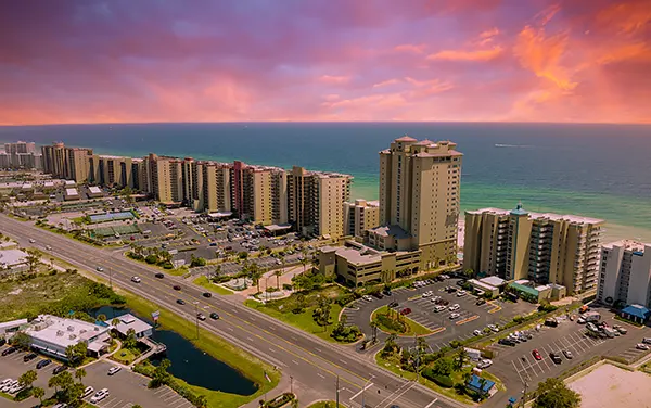 Orange Beach skyline at sunset on the Alabama Gulf Coast, beachfront condos and pink sky, used by Bliss Products and Services