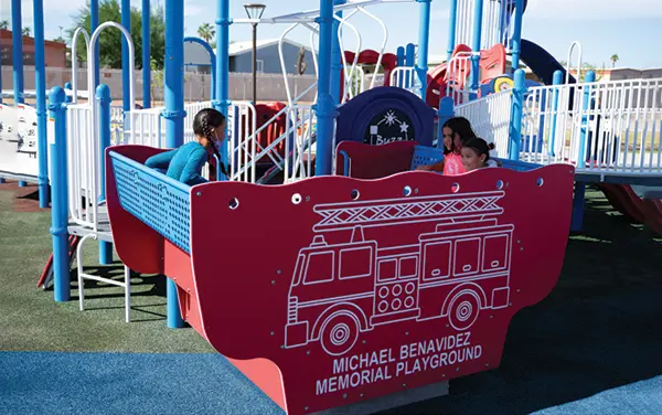 Children enjoying a themed firetruck play panel and group ride feature in Talladega County, Alabama, available from Bliss Products and Services.