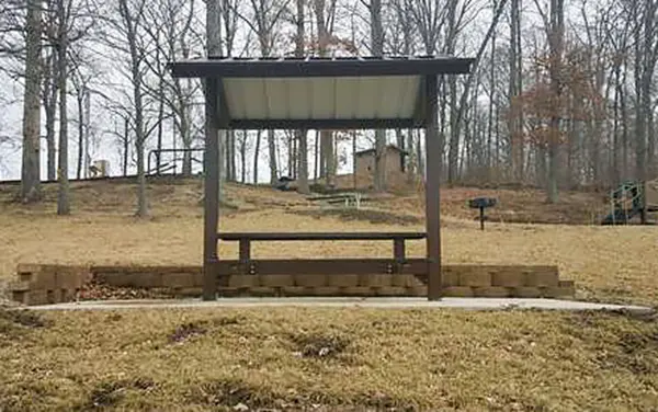 Small bench shelter with metal roof at a park rest area in Sipsey River Corridor, Fayette County, Alabama, available from Bliss Products and Services.