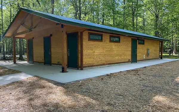 Wood restroom comfort station building in a park, available from Bliss Products and Services.