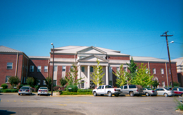Clarke County Courthouse in Grove Hill, Alabama with columned entrance and brick wings, Bliss Products and Services