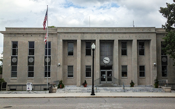 Franklin County Courthouse in Russellville, Alabama, with columns and a central clock. Used by Bliss Products and Services.