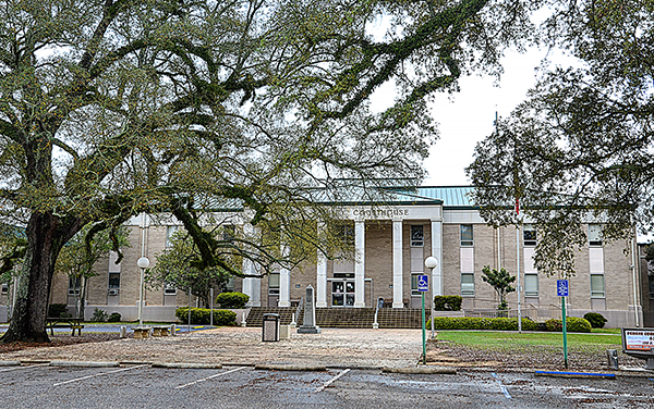 Geneva County Courthouse in Geneva, Alabama, with columned facade and live oaks. Used by Bliss Products and Services.