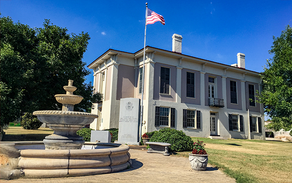 Greene County Courthouse in Eutaw, Alabama, two-story historic building with a fountain in the foreground. Used on Bliss Products and Services.