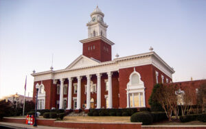 Lee County Courthouse in Opelika, Alabama, red-brick facade with white columns and clock tower. Used by Bliss Products and Services.