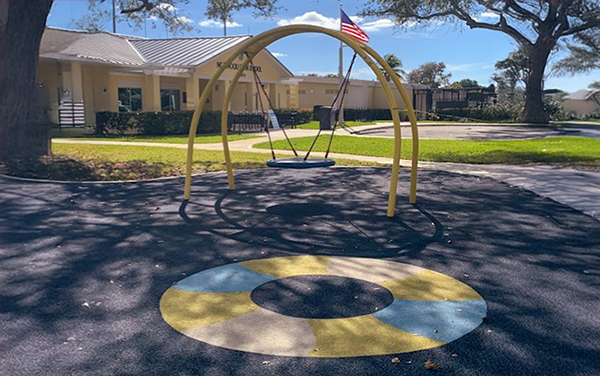 Aluminum bleachers with full-perimeter guardrails and a center aisle handrail at a sports field, available from Bliss Products and Services.