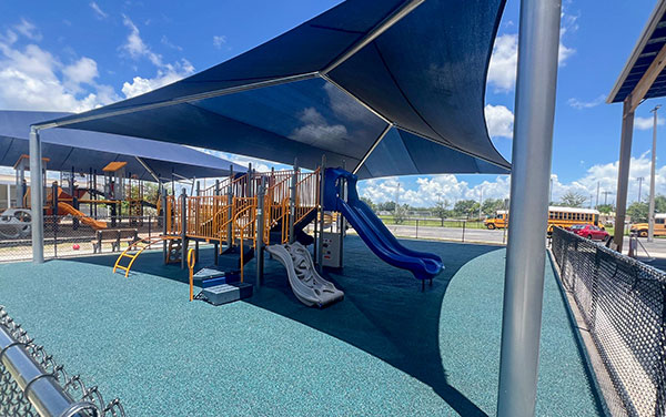 Oasis-Elementary-school-south-hero Rectangle hip shade with four posts covering a small playground