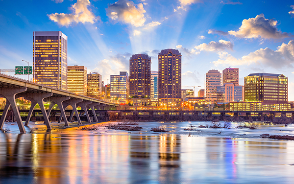 Richmond Virginia Skyline Over the James River | Bliss Products and Services Richmond Virginia skyline at dusk with buildings reflected in the James River, representing city and school communities served by Kelly Lindsay and Bliss Products and Services.