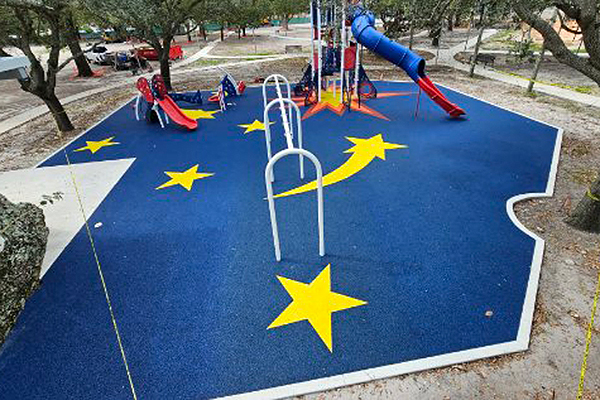 Rocket themed poured in place rubber playground surfacing with yellow stars at Scott Park in Miami Gardens, Florida, installed with support from Bliss Products and Services.