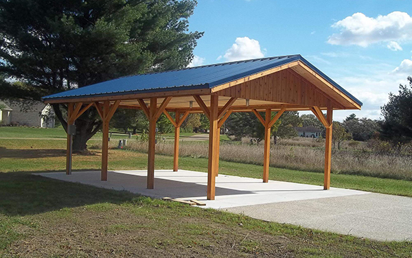 Aerial view of a steel hip-roof shelter by a playground, available from Bliss Products and Services.