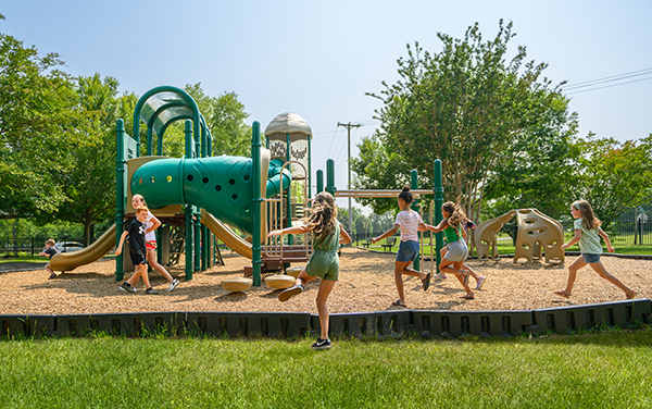 Little-General-Park City of Durham playground with new sidewalks, a picnic shelter, a colorful play area for ages 2 to 5, a tall adventure zone for ages 5 to 12, and an ID Sculpture caterpillar detail in poured in place surfacing — Bliss Products and Services