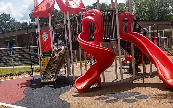 Blue bench under an integrated perforated metal shade structure.