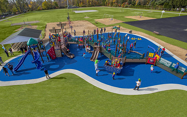 Aerial view of large elevated aluminum grandstand next to a blue running track.