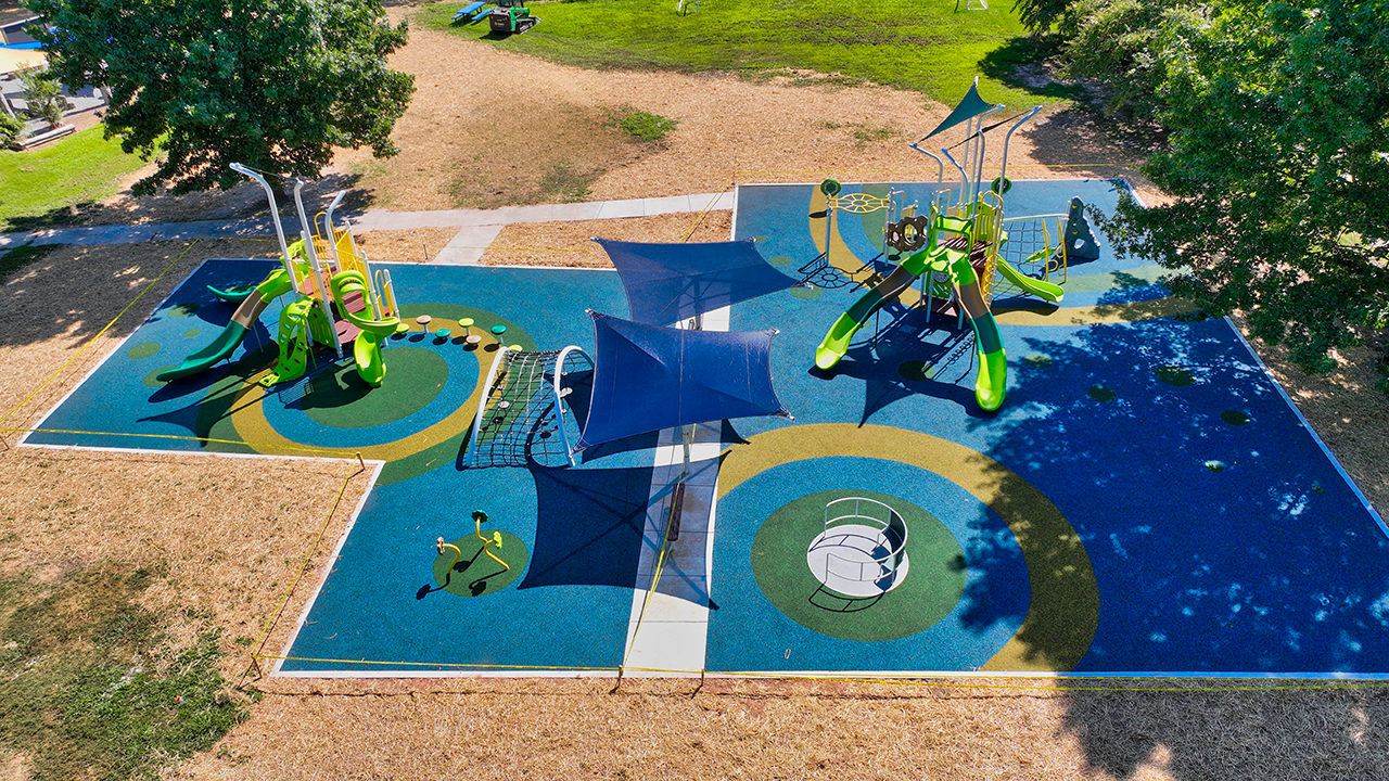 EK Powe Elementary playground aerial view with play towers, slides, and poured in place safety surfacing — Bliss Products and Services