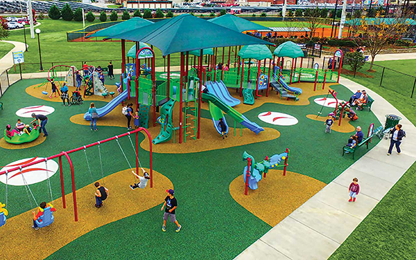 Inclusive playground at Miracle League Park in Chattanooga, Tennessee with shade canopies, slides, swings, and rubber safety surfacing | Bliss Products and Services