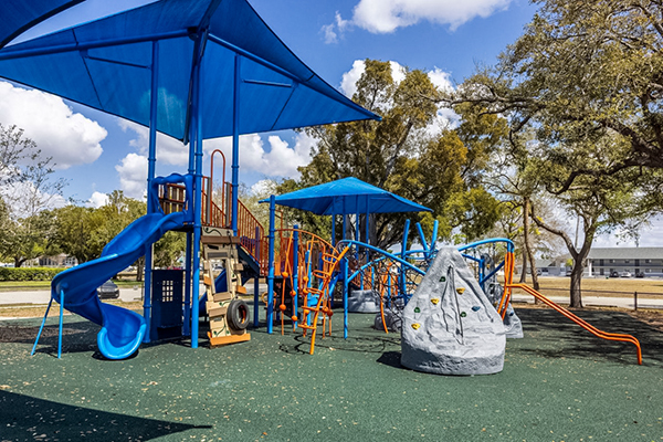 Shaded playground with multiple structures at Four Freedoms Park in Cape Coral Florida