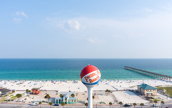 Aerial view of Pensacola Beach in the Florida Panhandle with the iconic water tower, white sand, and Gulf shoreline by Bliss Products and Services
