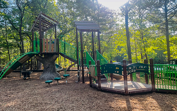 Playground climbing net and rock feature under shade canopy in Cape Coral Florida