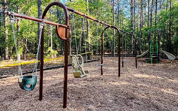 Playground structure with slides under blue shade canopy in Cape Coral Florida