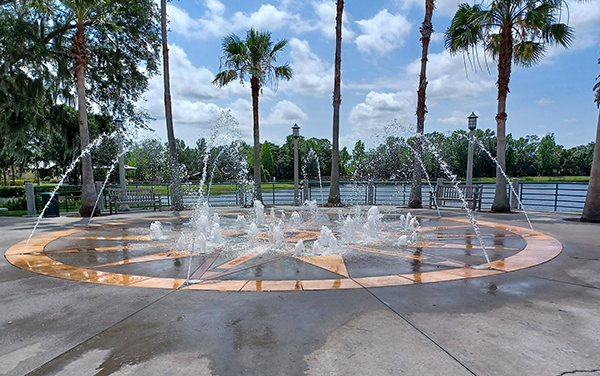 Waterfront fountain with benches and palm trees in Celebration, Osceola County, Florida.