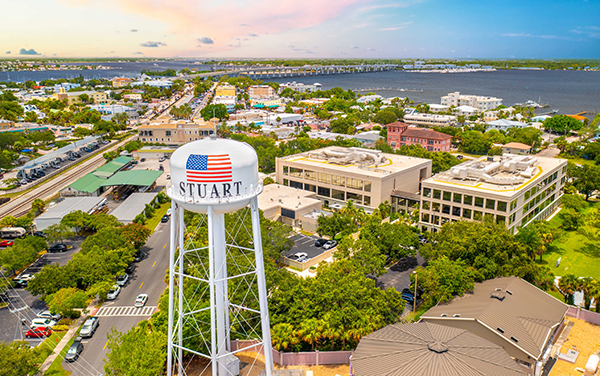 Aerial view of downtown Stuart, Florida, with the Stuart water tower, city streets, bridges, and the St. Lucie River in Martin County.