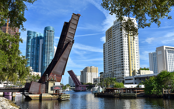 Drawbridges raised along the New River in downtown Fort Lauderdale, Florida, with waterfront buildings in Broward County.