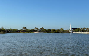 View across Lake Tradition in Port St. Lucie, Florida, showing water, shoreline, palms, and community buildings in St. Lucie County.