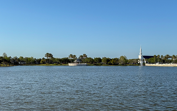 View across Lake Tradition in Port St. Lucie, Florida, showing water, shoreline, palms, and community buildings in St. Lucie County.