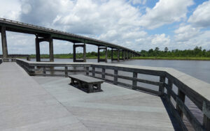 Satilla River Waterfront Park in Woodbine, Georgia, showing a boardwalk bench, river view, and public recreation space in Camden County.