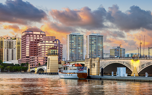 Sunset view of the West Palm Beach waterfront, skyline, marina, and bridge in Palm Beach County, Florida, representing Patty Carruthers’ Southeast Florida territory for Bliss Products and Services