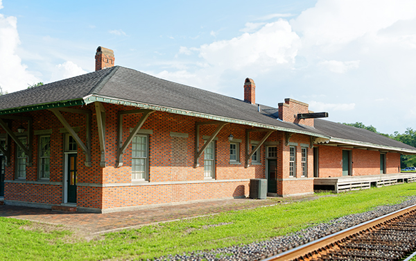 Historic brick Blackshear Depot beside railroad tracks in Pierce County, Georgia, featured by Bliss Products and Services