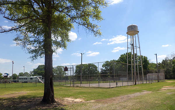 Bluffton Park in Clay County, Georgia, showing fenced recreation courts, open green space, and the town water tower.