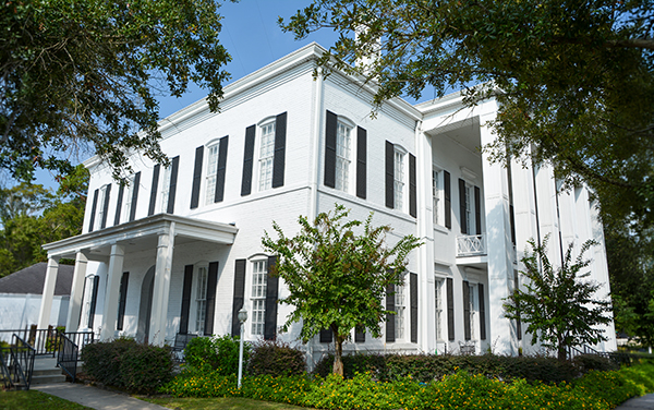 Clinch County Courthouse in Homerville, Georgia, surrounded by trees and landscaped grounds.