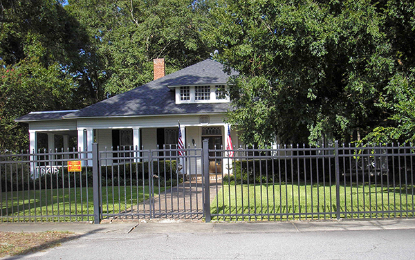 Historic Dr. James W. Daniel House behind a decorative fence in Claxton, Evans County, Georgia