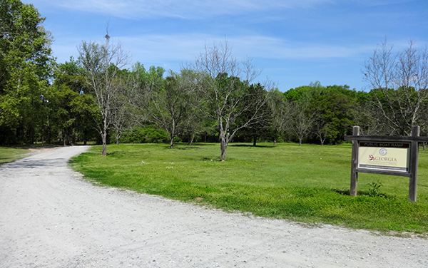 Entrance road, open green space and park sign at Flint River Park in Mitchell County, Georgia